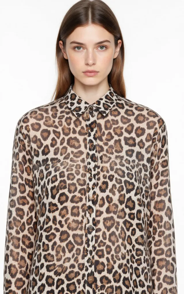 A French model wearing an Animal print pattern   printed shirt, against a white background, in a front   facing bust portrait
